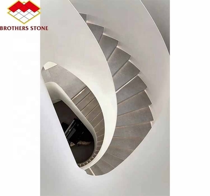 Escaleras en espiral de mármol natural en interiores con pisos pulidos y estilo moderno